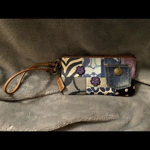 Coach denim patchwork wristlet with brown leather strap.
